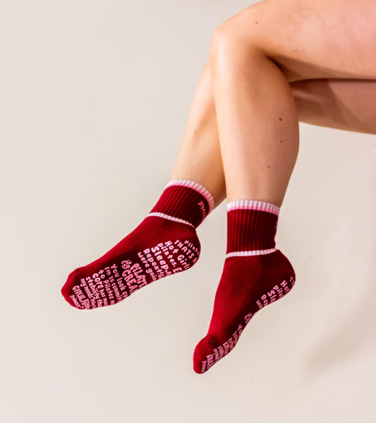 burgundy socks, with pink tonal tipping, pilates club embroidery and with pilates slogan grip sole on a neutral background